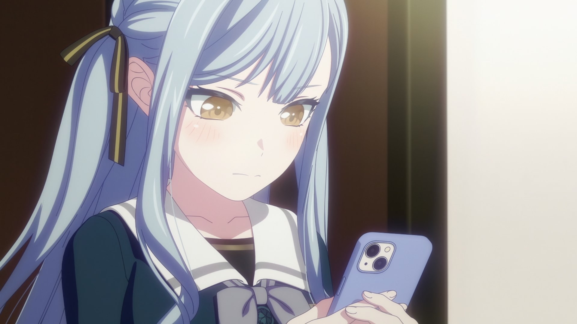 A close-up of Sakiko looking at her cell phone.